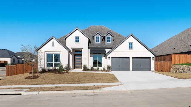 french country home with a front yard and a garage