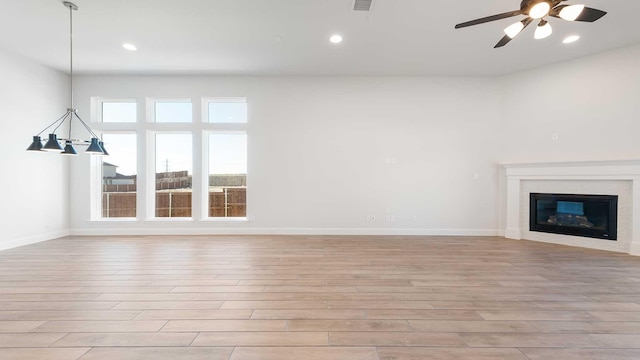 unfurnished living room with ceiling fan and light hardwood / wood-style floors