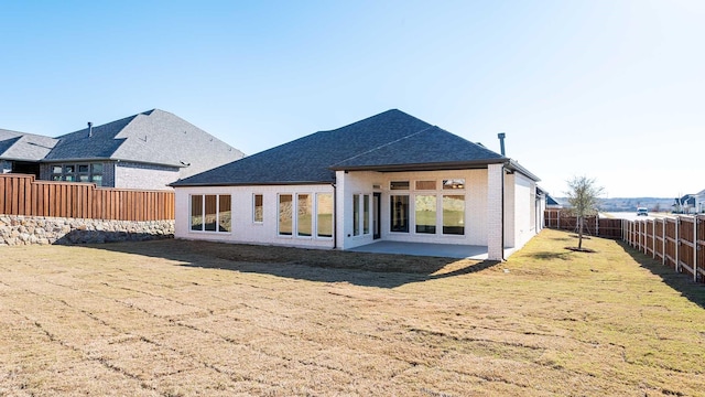 rear view of property featuring a lawn and a patio area