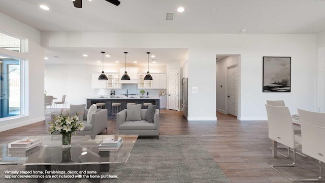 living room featuring dark hardwood / wood-style floors, ceiling fan, a healthy amount of sunlight, and sink