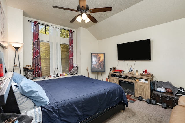 bedroom featuring a textured ceiling, light colored carpet, ceiling fan, and vaulted ceiling