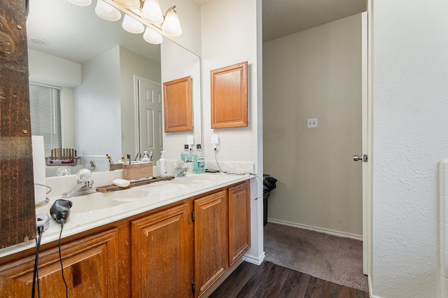 bathroom with hardwood / wood-style flooring, vanity, and a textured ceiling