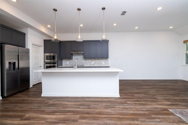 kitchen with sink, tasteful backsplash, hanging light fixtures, an island with sink, and stainless steel appliances