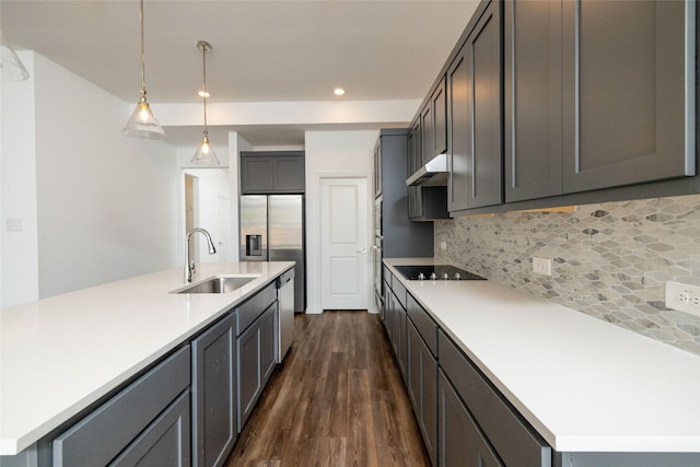 kitchen featuring decorative light fixtures, tasteful backsplash, sink, a kitchen island with sink, and stainless steel appliances