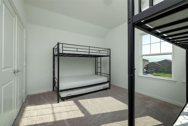 carpeted bedroom with lofted ceiling