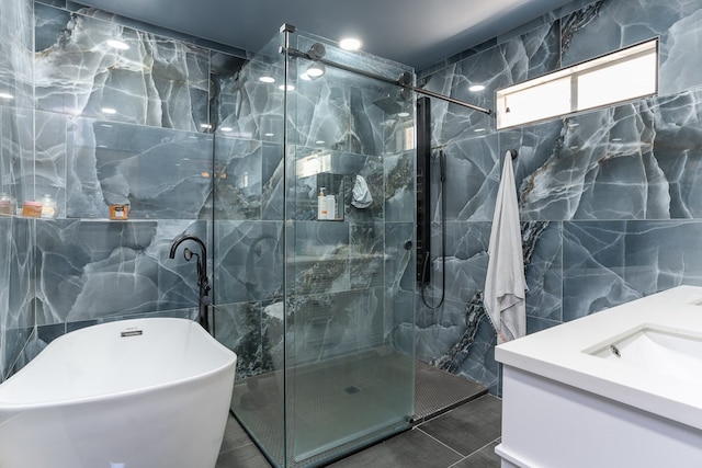 bathroom featuring tile patterned flooring, vanity, separate shower and tub, and tile walls