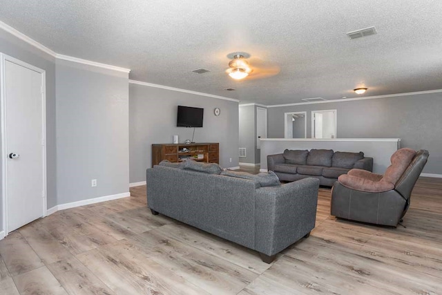 living room with a textured ceiling, light hardwood / wood-style flooring, ceiling fan, and crown molding