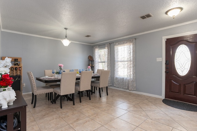 tiled dining area featuring a textured ceiling and crown molding