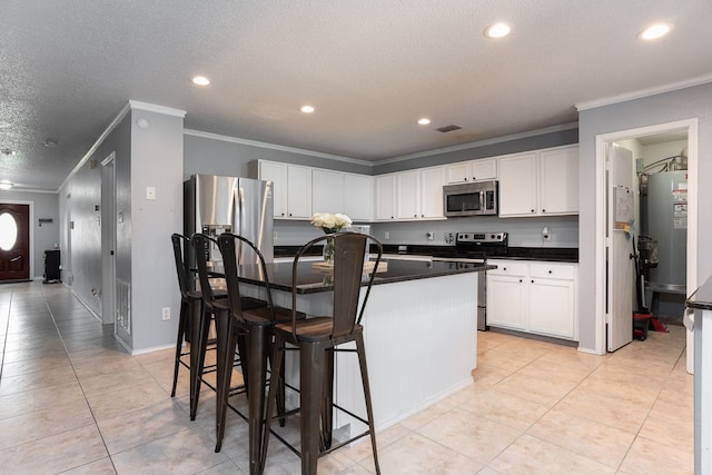 kitchen with stainless steel appliances, white cabinetry, a kitchen bar, a kitchen island with sink, and a textured ceiling