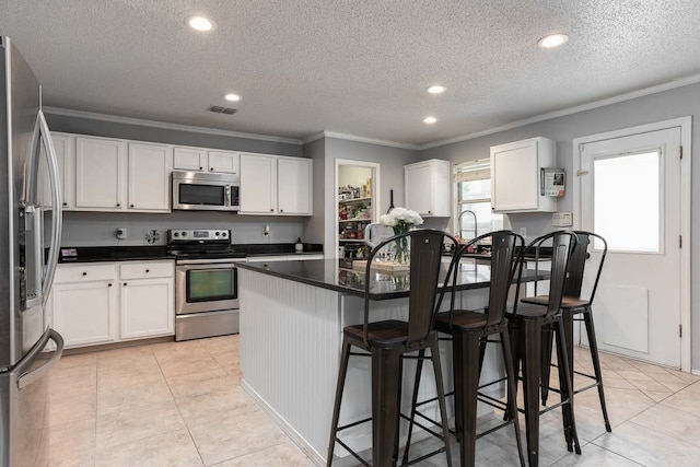 kitchen featuring white cabinets, appliances with stainless steel finishes, and a textured ceiling