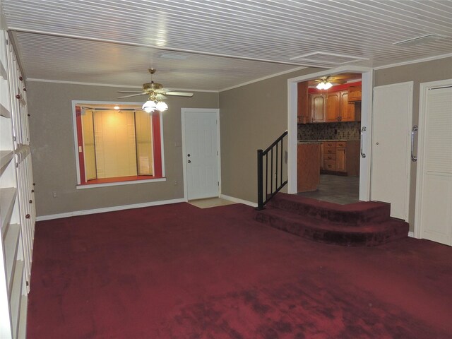 unfurnished living room featuring crown molding and dark colored carpet