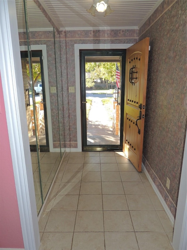 doorway with ornamental molding, plenty of natural light, and tile patterned flooring