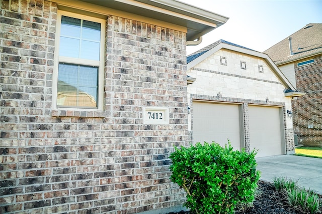 view of property exterior featuring a garage, brick siding, and concrete driveway