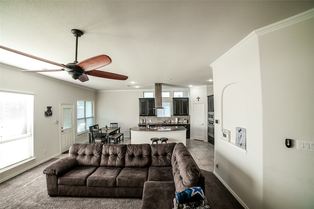 living room with ornamental molding, light carpet, and ceiling fan