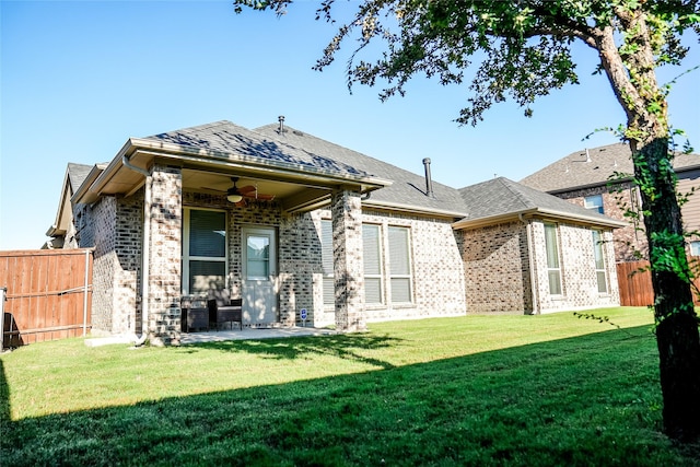 back of house featuring brick siding, ceiling fan, fence, a lawn, and a patio area