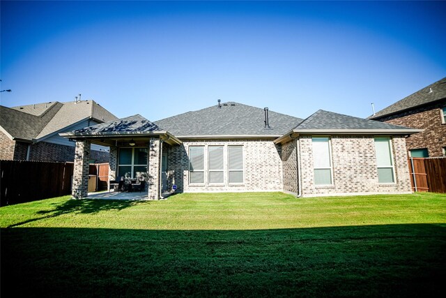 back of house featuring a lawn and a patio