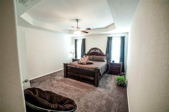 bedroom featuring visible vents, a raised ceiling, carpet floors, baseboards, and a textured wall