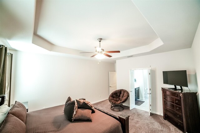 bedroom featuring a raised ceiling, ceiling fan, and carpet flooring