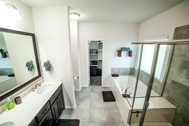 bathroom featuring a shower stall, tile patterned floors, a walk in closet, a bath, and vanity