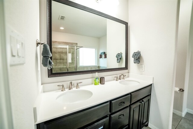 bathroom featuring tile patterned floors, an enclosed shower, and vanity