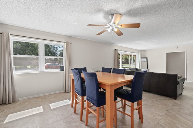 dining area with a textured ceiling and ceiling fan