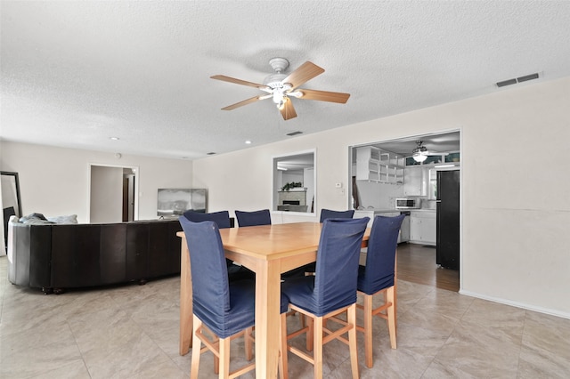 dining area featuring a textured ceiling and ceiling fan