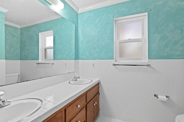 bathroom featuring a textured ceiling, vanity, toilet, and tile walls