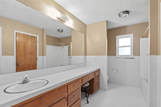 full bathroom with toilet,  shower combination, a textured ceiling, and vanity