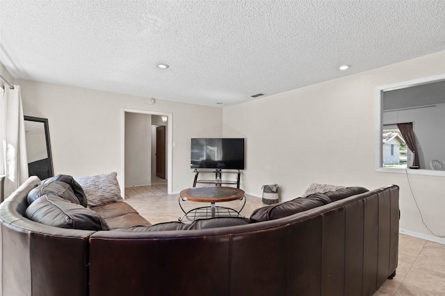 tiled living room featuring a textured ceiling