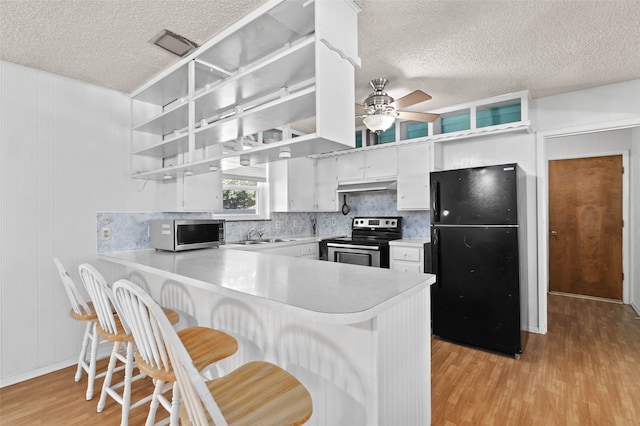 kitchen featuring light hardwood / wood-style flooring, kitchen peninsula, stainless steel appliances, and ceiling fan