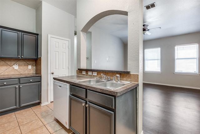 kitchen with ceiling fan, dishwasher, sink, tasteful backsplash, and light hardwood / wood-style flooring