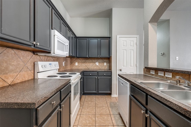 kitchen with white appliances, backsplash, sink, gray cabinets, and light tile patterned floors