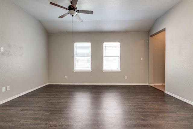 empty room with dark hardwood / wood-style flooring, vaulted ceiling, and ceiling fan