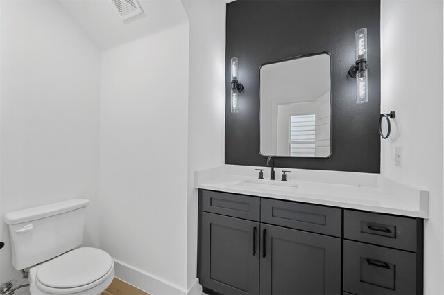 bathroom with vanity, toilet, and hardwood / wood-style floors