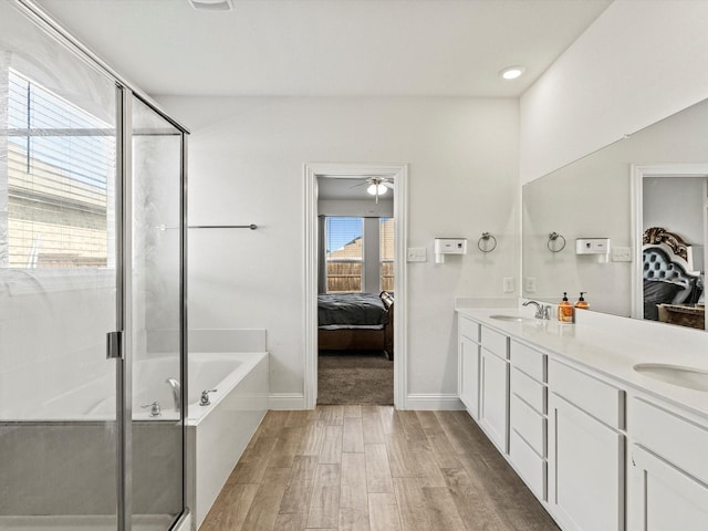 bathroom with separate shower and tub, plenty of natural light, vanity, and hardwood / wood-style flooring