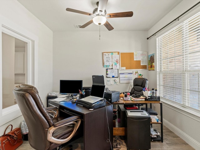 home office with ceiling fan and light hardwood / wood-style floors