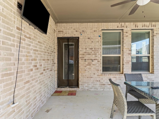 view of exterior entry featuring a patio area and ceiling fan