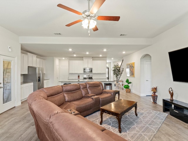 living room with ceiling fan and light hardwood / wood-style floors