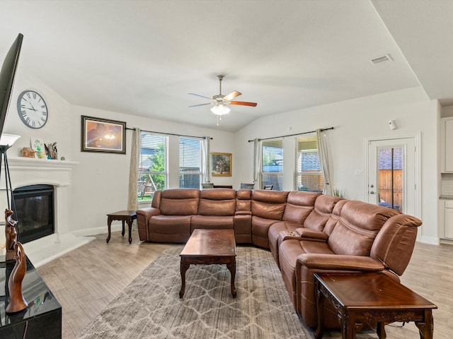 living room featuring ceiling fan, light hardwood / wood-style floors, and lofted ceiling