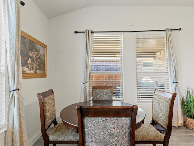 dining area featuring lofted ceiling and light wood-type flooring