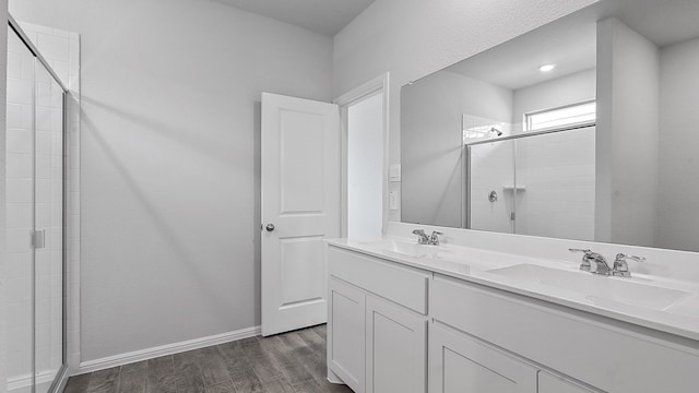 bathroom with wood-type flooring, an enclosed shower, and vanity