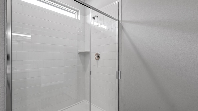 bathroom with a shower with door