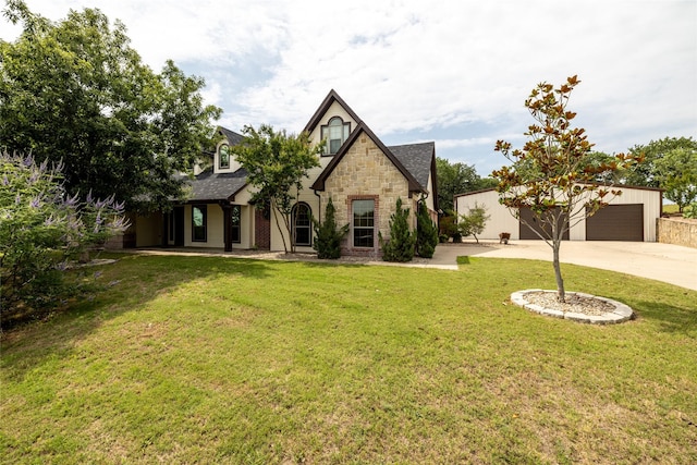 tudor home featuring a front yard and a garage