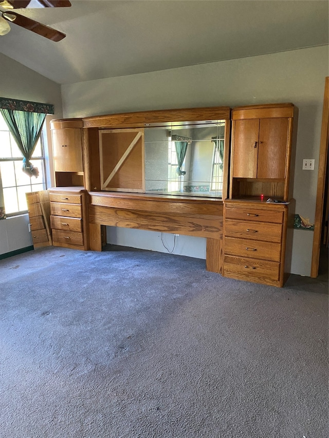 interior space with lofted ceiling, ceiling fan, and carpet floors