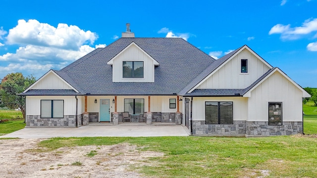 back of property with a yard and a porch