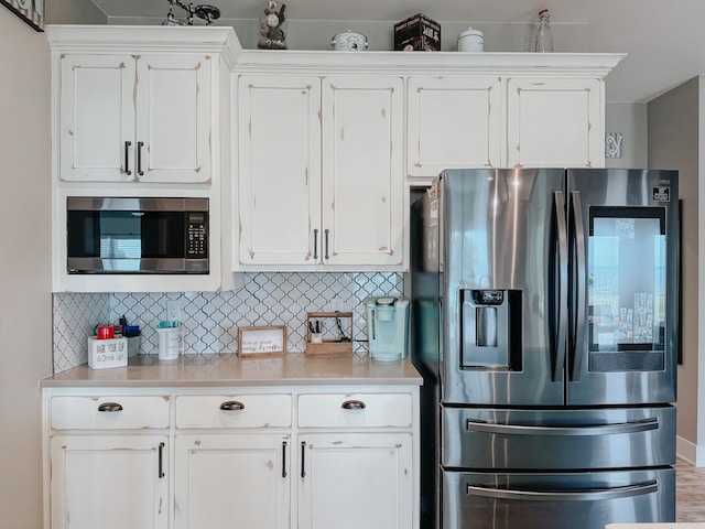 kitchen featuring stainless steel appliances, white cabinets, and tasteful backsplash