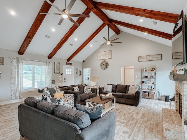 living room featuring light wood-type flooring, ceiling fan, high vaulted ceiling, and a fireplace