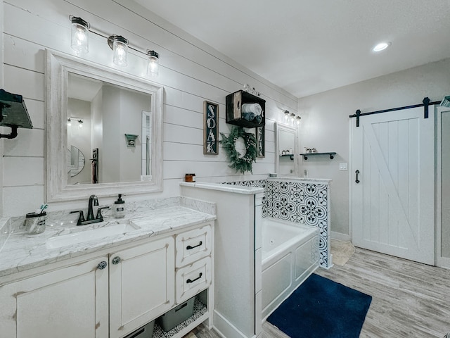 bathroom with vanity, hardwood / wood-style flooring, and a bathing tub