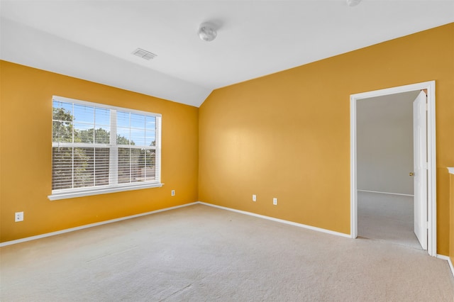 carpeted empty room featuring lofted ceiling