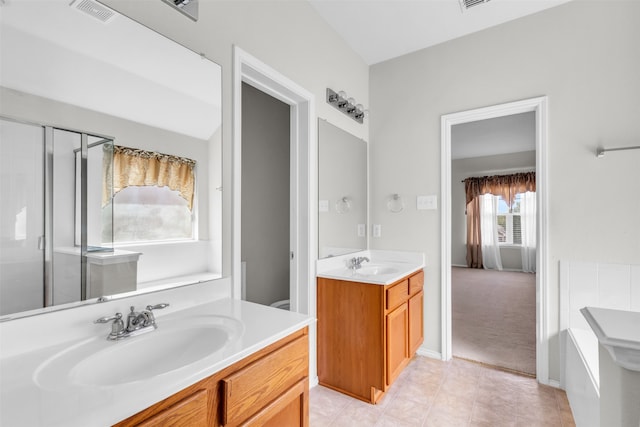 bathroom featuring vanity, a shower with shower door, and tile patterned floors